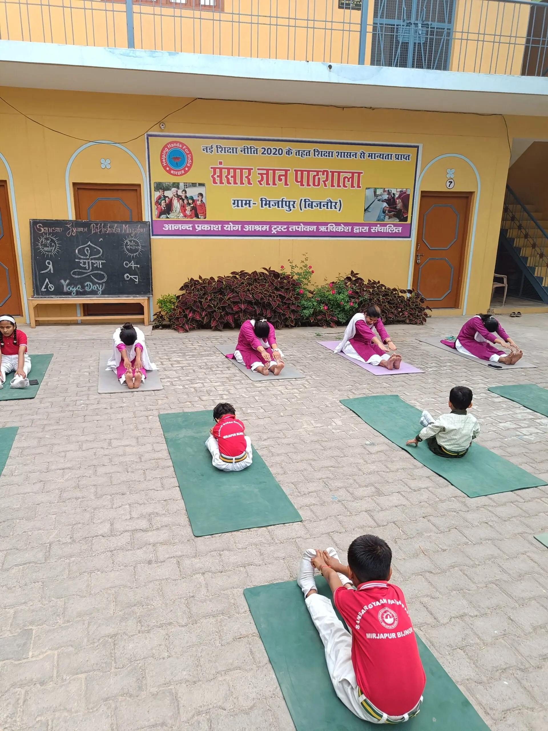A student practicing a seated forward bend on Yoga Day